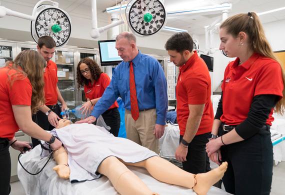 Image of faculty member demonstrating use of medical equipment during class.